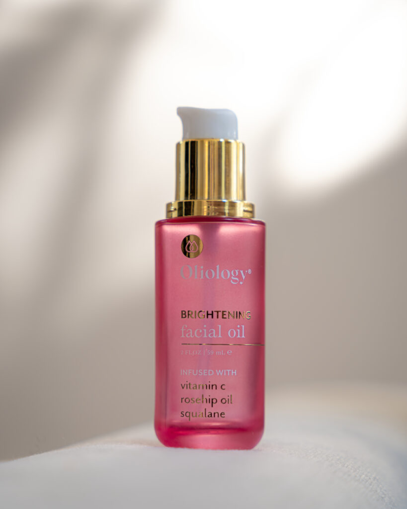 Minuit studio brand photo - Close up on an Oliology serum pump tube with pink and gold tones. photography is made on a white environment and includes play with shadows and lights