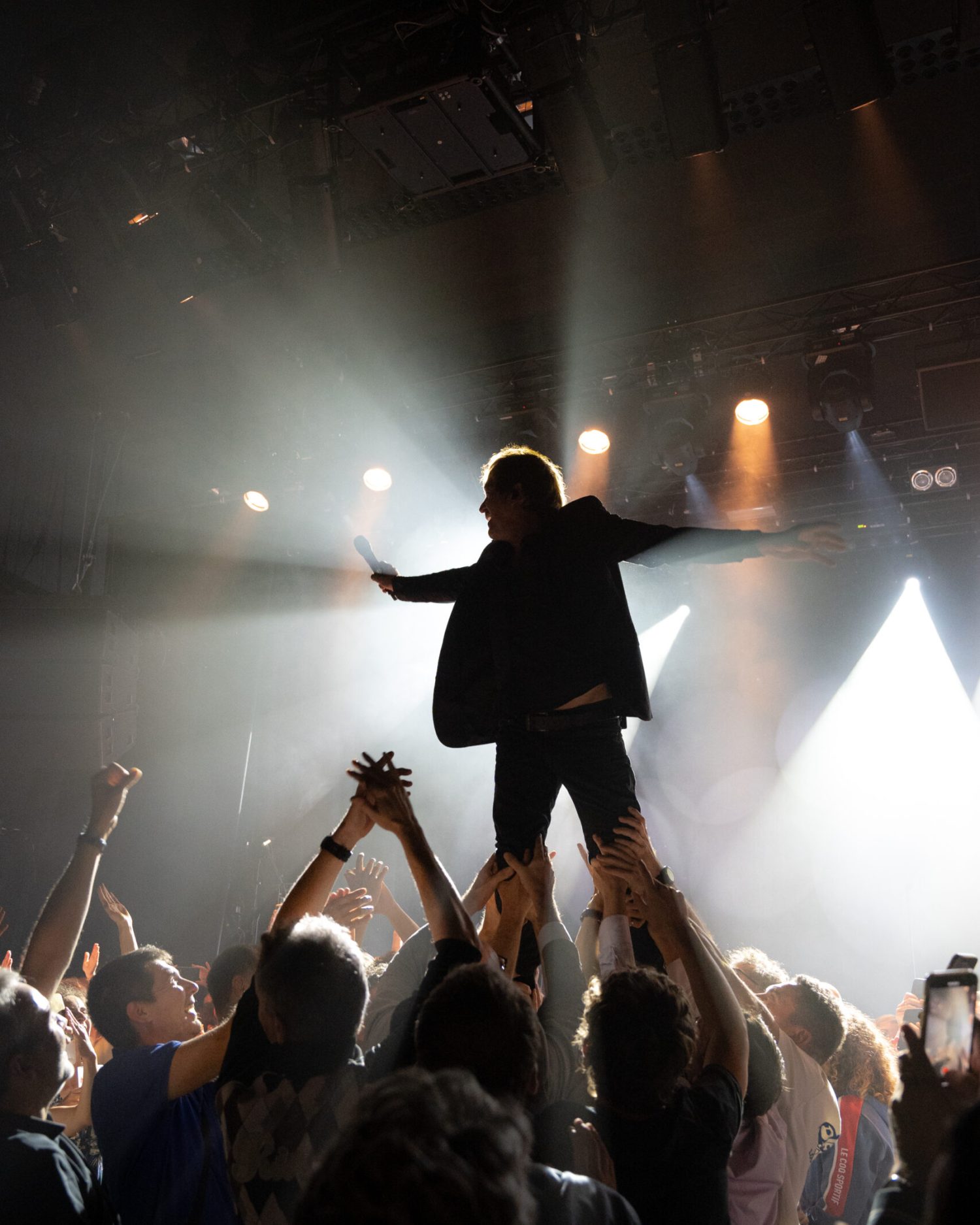 Minuit studio music photography - Concert photo of the French singer Cali during a live performance in Paris, he was held standing on the crowds shoulders with stunning lighting and energy coming out of the visual