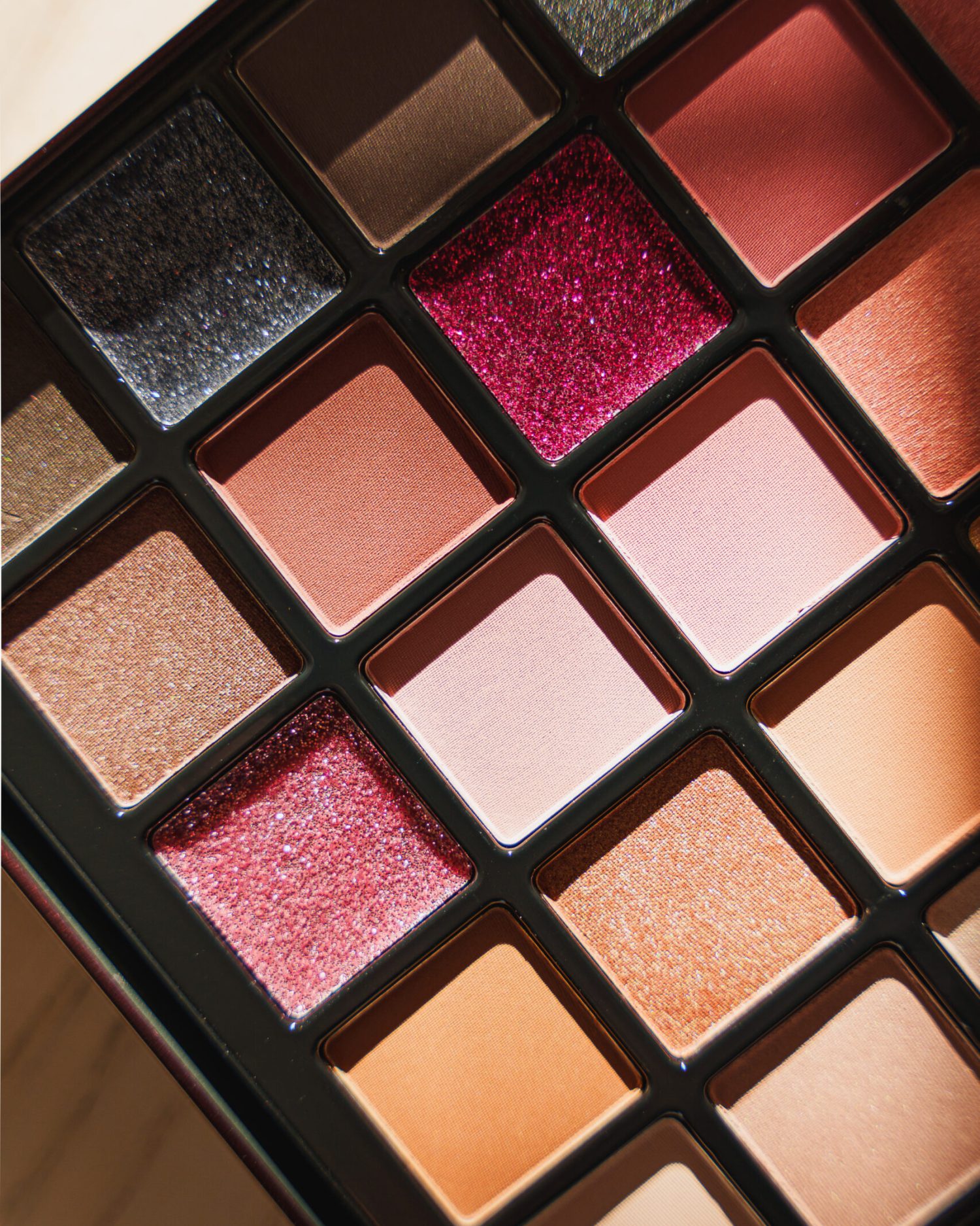 Minuit studio brand photography - Close up on an eye shadows make-up palette in warm tones including a game with light and shadows