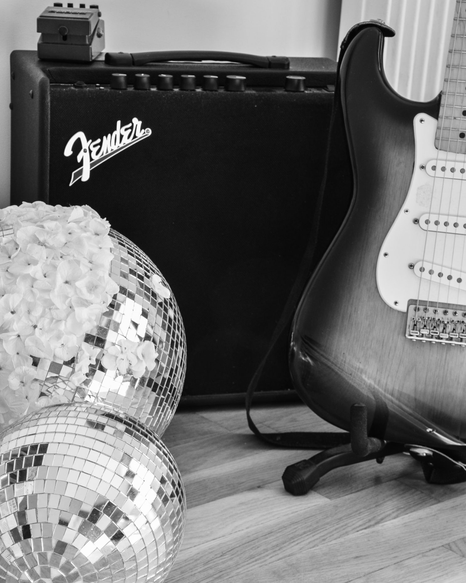 Minuit studio music photography - Black and white picture of a fender amplification with a fender guitar and disco balls decored with flowers